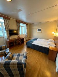 a bedroom with a bed and a desk and a couch at Brakanes Hotel in Ulvik