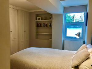 a bedroom with a bed and a window at Stunning 2 bed/2bath flat in heart of Kensington in London