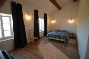 ein Schlafzimmer mit einem Bett und zwei Fenstern in der Unterkunft La Casa d'Anthony in Ginestas