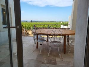 einen Tisch und Stühle auf einem Balkon mit Blick auf einen Weinberg in der Unterkunft La Casa d'Anthony in Ginestas