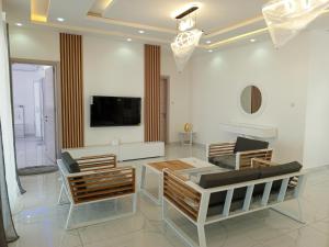 ein Wohnzimmer mit einem Tisch und Stühlen sowie einem TV in der Unterkunft Marijo Palace in Ndangane