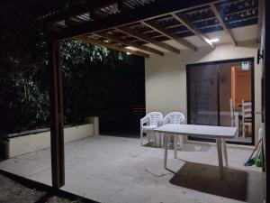 um pátio com uma mesa e cadeiras sob uma pérgola em BAHIA SAN FRANCISCO, casa Albatros a 80 metros del mar, Uruguay em Piriápolis