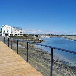 eine hölzerne Promenade neben einem Wasserkörper in der Unterkunft The place to be in Barneville-Carteret