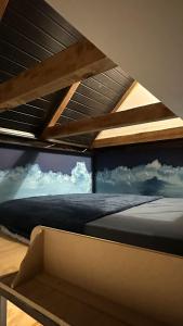 a bed in a room with a window with clouds at Hostel Hug Brasil in Curitiba