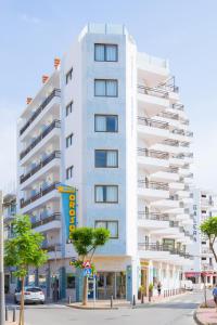 Un alto edificio bianco in una strada di città di Hotel Orosol a San Antonio