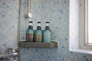 a shelf with three bottles of alcohol on a bathroom wall at Student Accommodation - 290 Hennessy Road in Hong Kong