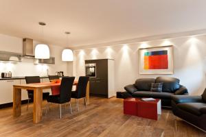 a living room with a table and a couch at Dorfhaus Chalets in Oberstaufen