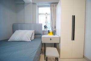 a bedroom with a bed and a table and a chair at Student Accommodation - 290 Hennessy Road in Hong Kong