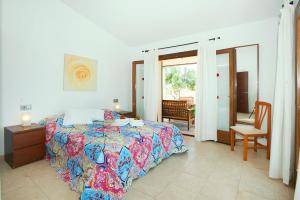 a bedroom with a bed and a table and a chair at Villa Figueral by Villa Plus in Alcudia