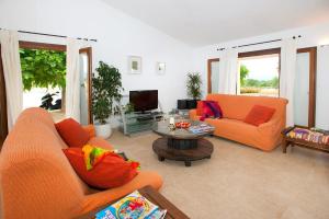 a living room with two orange chairs and a table at Villa Figueral by Villa Plus in Alcudia