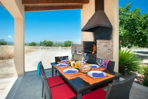 a dining table and chairs on a patio with a fireplace at Villa Figueral by Villa Plus in Alcudia