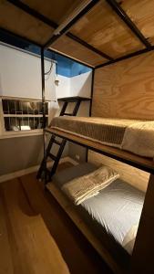 2 stapelbedden in een kamer met een raam bij Hostel Hug Brasil in Curitiba