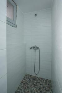 a shower in a white tiled bathroom with a window at Grandma's sifnos house in Platis Gialos +37 photos