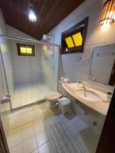 a bathroom with a shower and a sink and a toilet at Chez Max Pousada in Morro de São Paulo