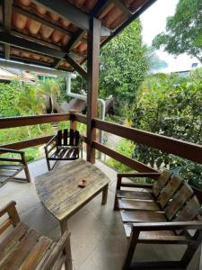 a wooden table and two chairs on a porch at Chez Max Pousada in Morro de São Paulo