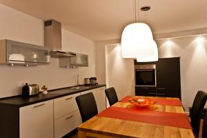 cocina con mesa de madera y comedor en Dorfhaus Chalets, en Oberstaufen