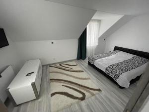 a bedroom with a black and white bed and a rug at Biertan 48 Guesthouse in Biertan