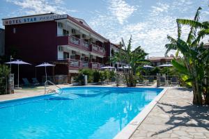 uma piscina de hotel em frente a um edifício em Star Paradise Hotel em Neos Marmaras
