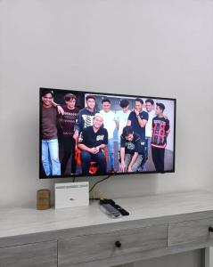 a tv screen with a group of people on it at ADEEN'S SURIA SUITE, Hotel Mutiara Gua Musang in Gua Musang