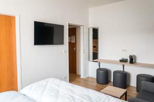 a bedroom with a bed and a tv on a wall at Antares Apartments in Düsseldorf