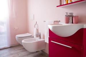 a bathroom with a white sink and a toilet at Ferragosto 2026 - Intera Villa con Piscina Privata Giardino BBQ Parcheggi in Verona +15 photos