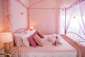 a pink bed with pink pillows and a canopy at Ferragosto 2026 - Intera Villa con Piscina Privata Giardino BBQ Parcheggi in Verona