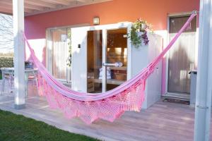 a pink hammock on the front of a house at Esclusiva Villa Romantica con Sauna & Piscina Privata a 10 minuti dall arena di Verona Il Rifugio Perfetto per una Fuga d'Amore in Verona