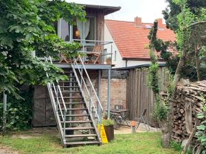 eine Leiter, die zu einem Haus mit einer Veranda führt in der Unterkunft Ferienwohnung Zur Alten Böttcherei in Kröslin