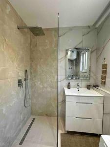 bagno con doccia, lavandino e specchio di Sunshine Apartment Tirana, Sheshi Wilson a Tirana