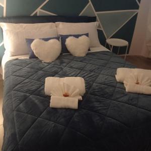 ein Bett mit weißen Kissen und einer schwarzen Bettdecke in der Unterkunft La dimora di Sandy in Viterbo
