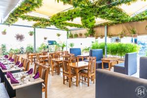 a restaurant with wooden tables and chairs and plants at Emboita Hotel Limited in Nakuru