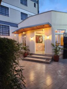 a house with a glass door in front of a building at Emboita Hotel Limited in Nakuru
