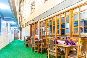 a restaurant with wooden tables and chairs and green carpet at Emboita Hotel Limited in Nakuru