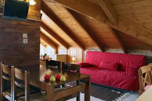 a living room with a red couch and a table at Villa Filoxenia Arahova in Arachova