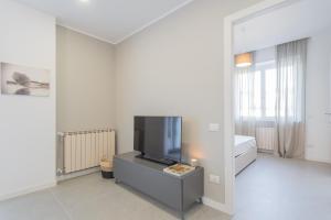 - un salon avec une télévision sur une commode dans l'établissement Isola Felice Grandate by Rent All Como, à Côme