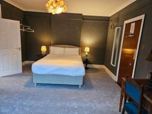 sypialnia z łóżkiem i żyrandolem w obiekcie Boutique Guest House w Galway