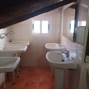 a bathroom with three sinks and a window at El Albergue Cirat in Cirat
