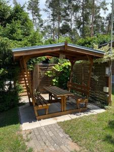 - un kiosque en bois avec un banc en bois dans l'établissement Feriensiedlung Kiefernhain, à Krakow am See