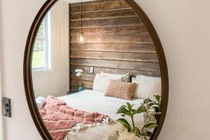 a bedroom with a bed in a mirror at Forget Me Not Farm Cottages in Coopers Shoot