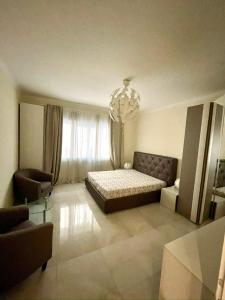 a bedroom with a bed and a couch and a chandelier at Appartamento Lungo Il Canale - Via Trento - 6 persone in Trieste