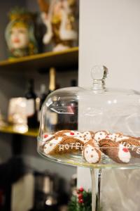 a glass dish with cookies on top of it at Alma Hotel in Palermo