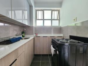 a kitchen with a black stove and a sink at Tenbury by the beachfront 806 in Durban