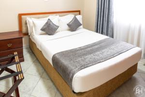 Säng eller sängar i ett rum på Emboita Hotel Limited