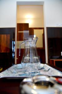 a glass vase sitting on a table with a spoon at Prince Recidency in Bangalore