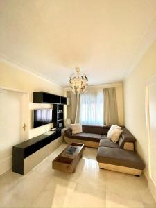 a living room with a couch and a chandelier at Appartamento Lungo Il Canale - Via Trento - 6 persone in Trieste