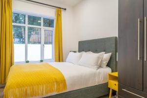 a bedroom with a large bed with yellow curtains at NEW Luxury family/dog-friendly countryside retreat in Kirkby Thore