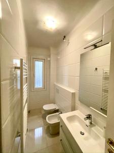 a white bathroom with a toilet and a sink at Appartamento Lungo Il Canale - Via Trento - 6 persone in Trieste