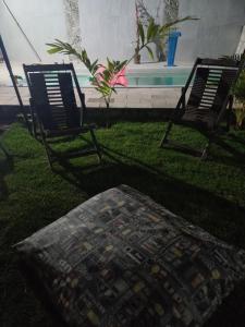 due sedie e un pouf seduti in un cortile di Suíte com piscina na praia de Tamandaré a Tamandaré
