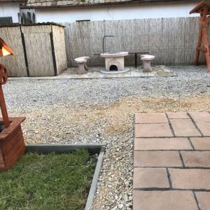 a backyard with a stone patio with two toilets at Flóra vendégház Tiszafüred in Tiszafüred