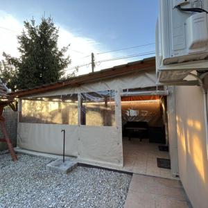 um edifício com uma parede branca e uma garagem em Flóra vendégház Tiszafüred em Tiszafüred